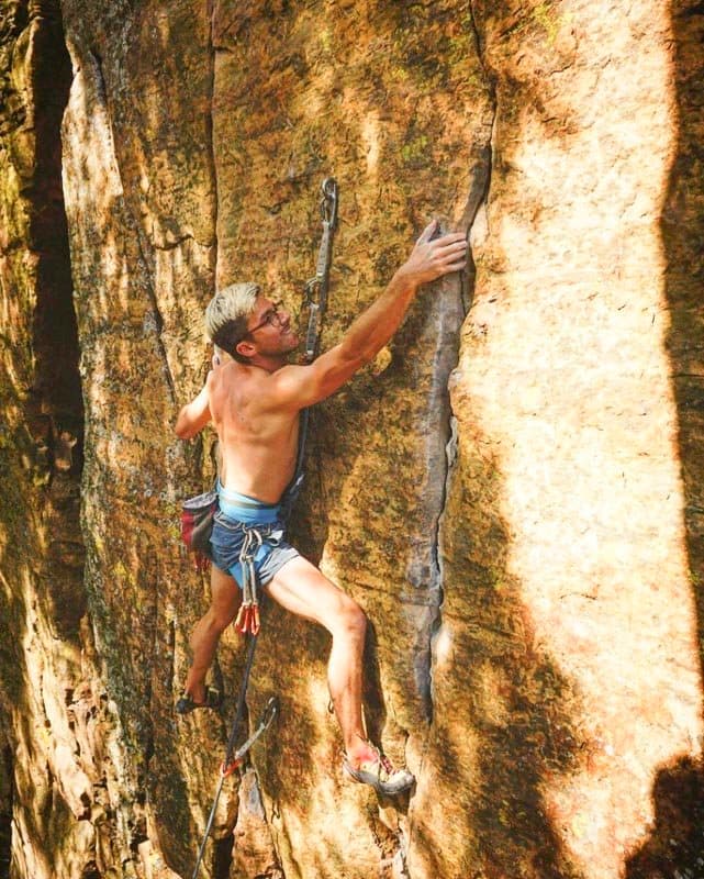 A climber documenting movement on a rock route